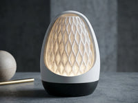 3CHIC The Forma lamp glowing softly, white egg-shaped shell around a ribbed diamond-patterned shade on a black base, USB powered LED, made in Dubai